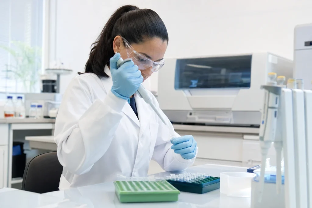 Pesquisadora utilizando micropipeta em laboratório